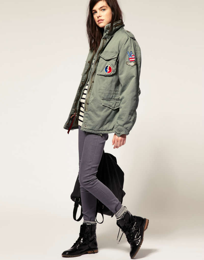 Девушка в куртке Alpha Industries, узких брюках и высоких военных ботинках